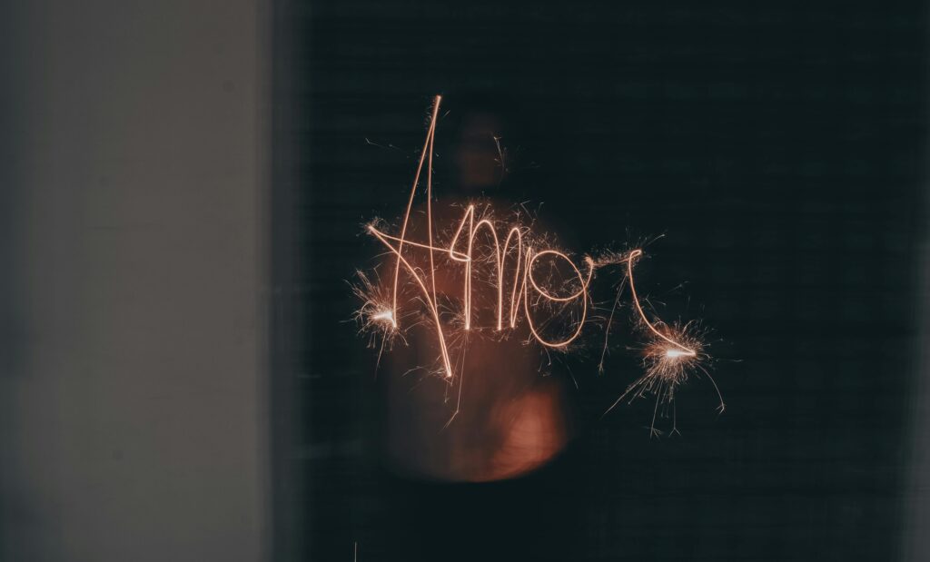 A sparkler writes the word 'Amor' in a dark setting, capturing the essence of love and celebration.